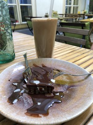 Caramel cake and latte with vegan chocolate sauce at My Secret Garden Cafe in Vienna