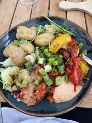 This was a vegan bowl, on the bottom baby spinach and topped with hummus, guacamole, and some kind of aioli, pumpkin seeds, green onions, baby potatoes and grilled peppers.  at Café & Bar Celona - Wandsbek in Hamburg