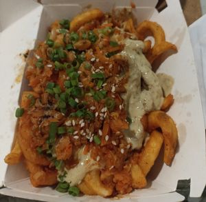 Kimchi fries: curly fries with green onions, sesame seeds, vegan sauce & vinegar at Anti Burger in Panama City
