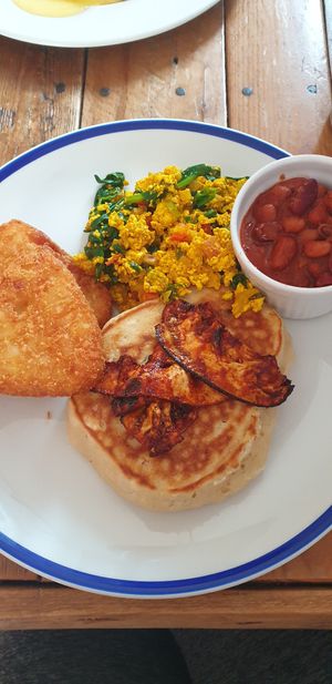 Scrambled tofu with spicy beans, hash browns, pancakes and aubergine "bacon" at Unity Grill in Ayr