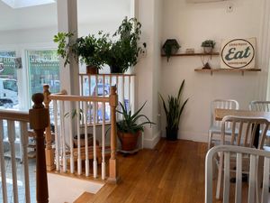Indoor seating area with stairs and plants at Juicygreens in Jamaica Plain