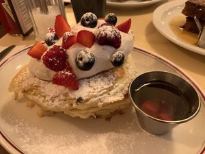 Vegan pancakes topped with berries and lemony whipped cream and maple syrup  at The Breakfast Club in London