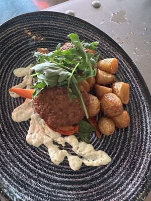 Vegan lentil and soya patties with an herbed yogurt sauce, vegetables, and crispy garlic oil potatoes   at Rosso in Porvoo