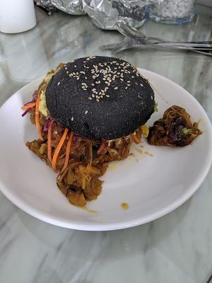 Jackfruit burger (a la pulled pork) in a spooky black (charcoal) bun  at Roots Plant-Based Cafe in Da Nang