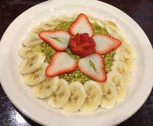 rosewater whip cream covered with honey, chopped pistachios, bananas, and strawberries at Skaf's Lebanese Cuisine in Glendale