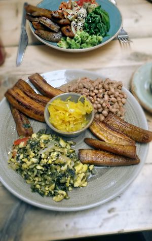 Foreground - vegan brunch 
Background - vegan Buddha bowl (spelt/plantain (GF), spinach, avocado salsa, kimchi, Sicilian artichoke, pomegranate molasses and black sesame seeds)  at Luca's Kitchen and Bakery  in South East London