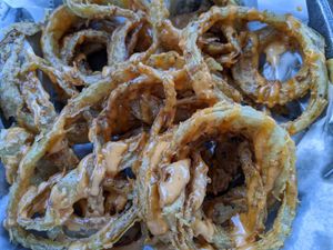 Cajun rings - thinly sliced onion rings in a well seasoned light batter with scallions, remoulade sauce at Houston Sauce Co in Houston