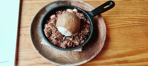 Dessert with nectarine, caramel, crumble and vanilla ice cream at Orteá - Vegan Collective in Lisbon