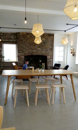 Pale wood furniture with open fireplace at Bean and Bread in Abergavenny