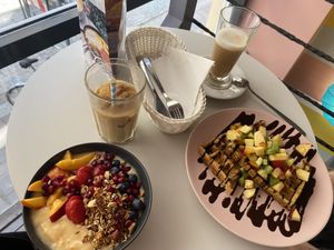 Vegan smoothie bowl, vegan waffles with fruit and chocolate sauce, iced coffee with oat milk and oat latte  at Cakester Cafe in Krakow