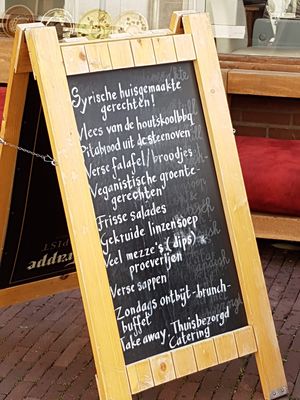 sign on pavement mentions vegan at Syrisch Eethuis Moushmoush in Arnhem