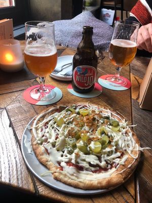 a small (sharing is caring menu) dirty vegan pizza with tomato sauce, seitan, cabbage, 3 (!!) types of onions (red, pickled & fried) + garlic sauce on top   at Otomat in Bruges