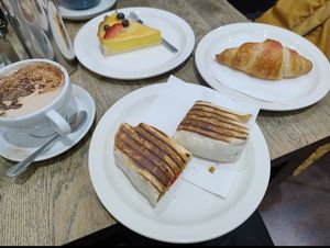 Oat hot chocolate, vegan custard tart, vegan falafel wrap with salsa and a vegan raspberry croissant at La Duchesse in North London