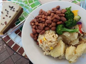 Bowl of sides: pinto beans, dill potatoes, vegetable medley, and veggie rice. Plus raw vegan chocolate orange cheesecake. at Food and Thought in Naples
