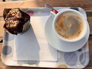 Chocolate and gooey caramel muffin, coffee with oat milk  at Pasteleria Serra in Gandia