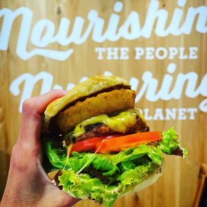 Aloha Pride Burger: beyond burger patty, crispy onion rings, tempeh bacon, grilled pineapple, vegan provolone, and sweet hunny hickory sauce at Next Level Burger - Potrero Hill in San Francisco