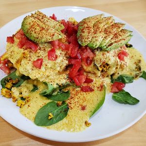 Biscuits and tofu scramble with hollandaise, spinach, tomato, and some free avocado our server threw on. SO delicious. Photo taken April 2019. at Sweetpea Baking Company in Portland