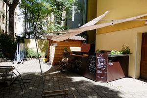 the bistro is located in a peaceful backyard garden with well-grown trees and a ping pong table
 at Paralela in Prague