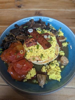 Pancakes with tofu and this isn't bacon. Added tomatoes and mushrooms at The Old Gun Shop Café & Pantry in Lancaster