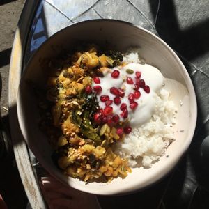 Cauliflower and Chickpea Tagine with Purple Sprouting Broccoli, Rice, Coconut Yoghurt and Pomegranate   at The Old Gun Shop Café & Pantry in Lancaster