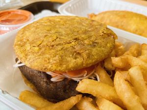 platano power sandwich with chimi sauce, fries, and an empanada at Next Stop Vegan - Washington Heights in New York City