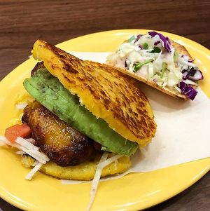 This is a sweet corn arepa with avocado, fried plantains, jicama, tomato, and black bean sauce at Pica Pica Arepa Kitchen in San Francisco