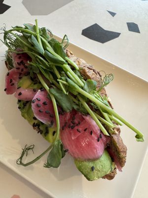 Wholemeal croissant filled with avocado, pickled onion and pea shoots.  at Puistokahvila Makia in Oulu