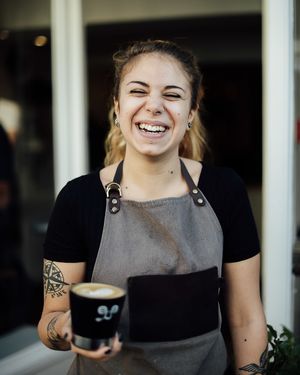 Vegan staff member Val serving oat milk coffee at Jaunty Goat - Bridge St in Chester