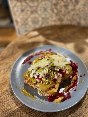 FRENCH TOAST (V) -made from our homemade challah with almond praline, pistachio cream, spicy coconut caramel, pear raspberries & crumbled pistachio  at Relax na Wilczej in Warsaw