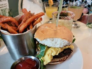 Vegan breakfast sandwich on a gluten-free bun with a side of sweet potato fries. at Naive in Louisville