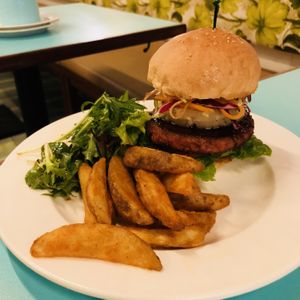 Asian Sensation Burger: Soy-Ginger Glazed Beyond Burger Patty, Rainbow Slaw, Caramelised Pineapple, Vegan Aioli, Hoisin, Romaine, Vegan Burger Bun, and a side of Potato Wedges and Mesclun. at Privé - Asian Civilisation Museum  in Central Singapore