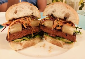 Asian Sensation Burger: Soy-Ginger Glazed Beyond Burger Patty, Rainbow Slaw, Caramelised Pineapple, Vegan Aioli, Hoisin, Romaine, Vegan Burger Bun, and a side of Potato Wedges and Mesclun. at Privé - Asian Civilisation Museum  in Central Singapore