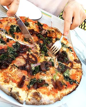Padana pizza with vegan cheese, tomato sauce, caramelized onions, spinach, red onions & garlic oil. at Pizza Express in Paphos