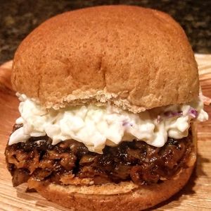 Magic Vegan's Famous BBQ Sandwich - Homemade wheat based meat substitute shredded in barbecue, topped with our coleslaw and a side of potato salad at Magic Vegan Cafe in Gulfport