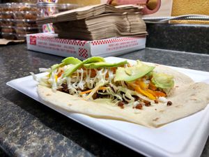 Taco Burrito - Homemade tofu meat with refried beans,shredded veggies, homemade sour cream and cheese sauce and avocado at Magic Vegan Cafe in Gulfport