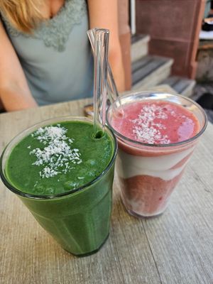 Smoothies (6.50): spirulina, mango, spinach, banana, coconut rice milk (green); Coconut milk, strawberries, banana, dates, coconut yoghurt (red/white) at Cafe Nomad - Weststadt in Heidelberg
