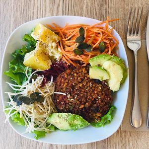 Salade du jour: crudités, tranches d’avocat, sésame, graines de courge, salade de pommes de terre et galette de graines de kasha et fruits secs 
 at Be Kind Cafe in Geneva