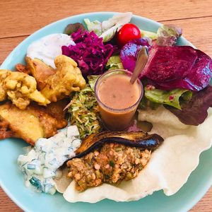Assiette mezze: salade / crudités / courgettes crues râpées à l’huile d’olive / raïta de concombre / papadum / salade indienne aux lentilles corail et aubergine confite /c at Be Kind Cafe in Geneva