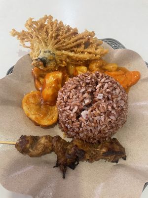 Brown rice ball with potatoes, sweet and sour veggies and fried veggies.   at Vegan House in Jakarta