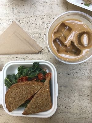 Sandwich with cashew cheese, kale and cherry tomatoes. Iced coldbrew latte. at Mora Mora - Roma in Mexico City