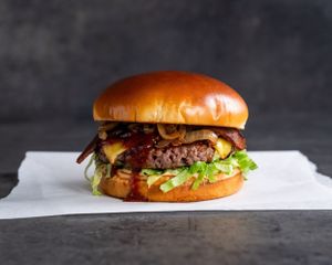 BBQ Bacon - Grilled Impossible patty with provolone, bacon, pickles, grilled onions, lettuce BBQ sauce, and chipotle mayo on a brioche bun at Stand-Up Burgers in Berkeley