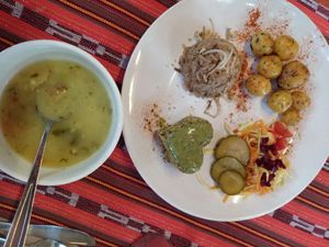 Corn soup, and main plate with rice, potatoes, salad, and mixed grains with pesto sauce on top at Alma Natura in Medellin