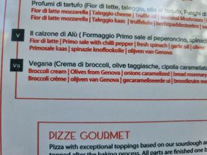 Vegan pizza clearly labelled on menu at Amuni in Bruges