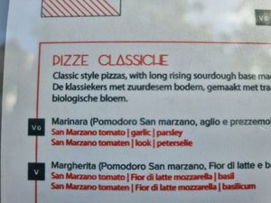 Vegan pizza clearly labelled on menu at Amuni in Bruges