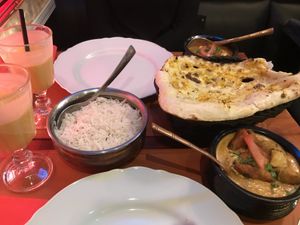 All vegan: mango lassi, garlic naan, a curry with kebab and one with potatoes   at Royal India in Ghent