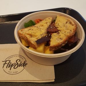 unrise breakfast bowl. Crispy facon, tofu scramble, grilled mushrooms and tomatoes served with 'buttered' toast at Flipside in London