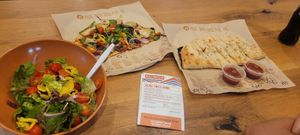 Half pizza with a salad and breadsticks with vegan cheese at Blaze Pizza in Melbourne