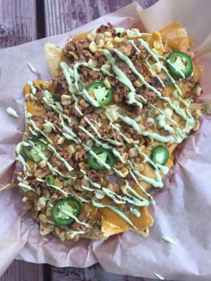 100% organic plant-based nachos. House-made refried beans (no-oil), house-made cheese (nut-free), seared corn salsa, fresh salsa with a grille of house-made cilantro-lime sauce (contains nuts). Pictured with an add-on of grilled marinated tempeh.  at New Public - Food Truck in Bellingham