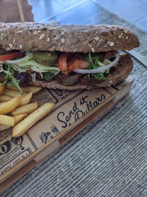 Seitan Sub: Seitan served in wholemeal baguette, mixed leaves, beef tomatoes, onions, gherkins, sriracha mayo and side of chips. at Balance Bowl in Gzira