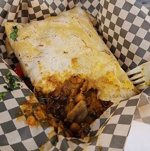 Trini Roti: traditional roti with a ‘wrap’ stuffed with ground split peas, then filled with curried chickpeas and potato, topped with homemade tamarind sauce and chilli sauce  at ITIS in East London